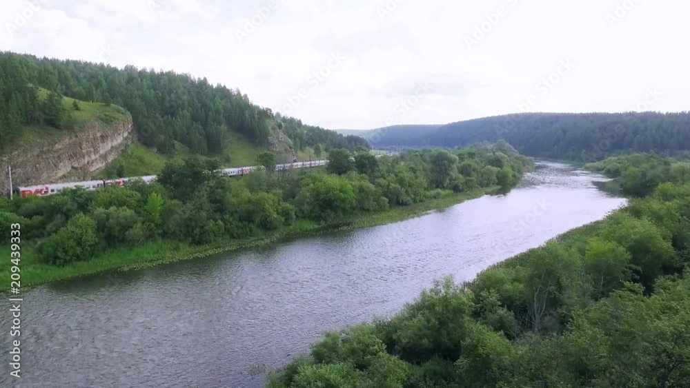 Passenger train an electric locomotive under the rock by two-sided winding railway in the Ural Mountains - Aerial Photography, top view Passenger train an electric locomotive under the rock by two-sided winding railway in the Ural Mountains - Aerial Photography, top view