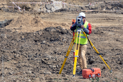 The surveyor is shooting at a building site photo