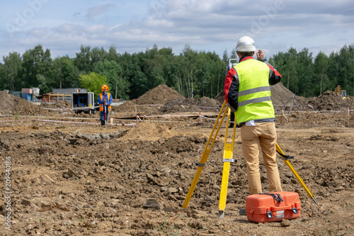 The surveyor is shooting at a building site photo