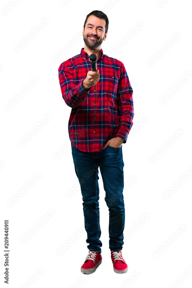 Handsome man holding a microphone and singing. Handsome man holding a microphone and singing.