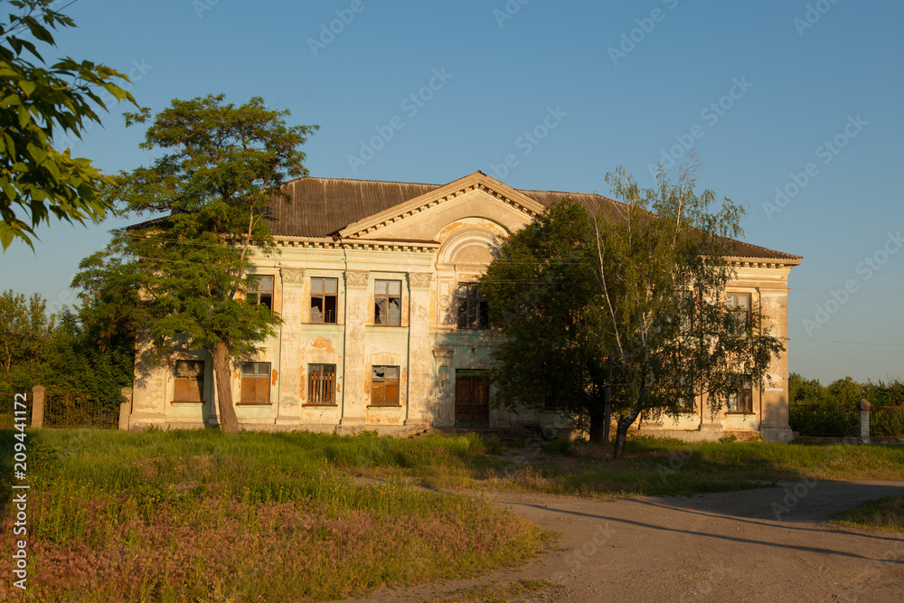 An old abandoned two-story building in the village early morning sun
