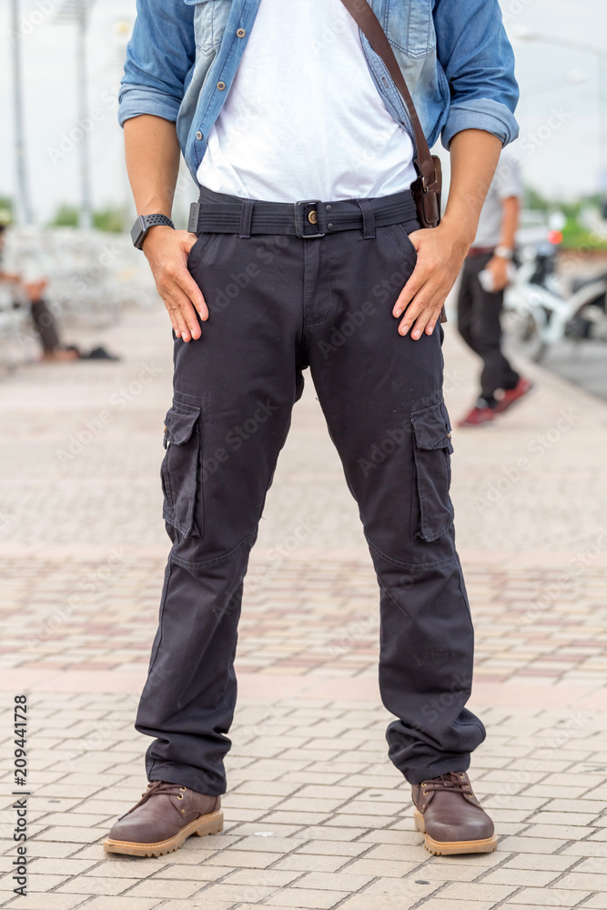 male tourist wearing cargo pants standing in the park. male tourist wearing cargo pants standing in the park.