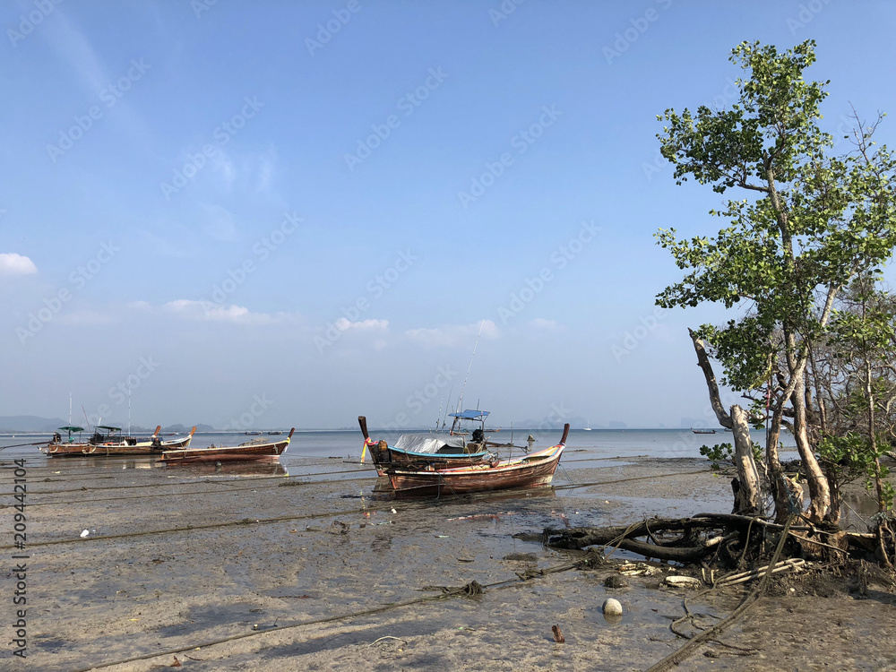 Long-tail boats during low tide Long-tail boats during low tide