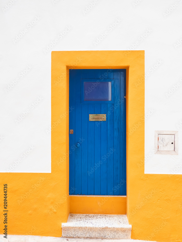 Fachada y puerta de colores amarillo, blanco y azul, tipica de la ciudad antigua de Dalt Vila en Ibiza, España Fachada y puerta de colores amarillo, blanco y azul, tipica de la ciudad antigua de Dalt Vila en Ibiza, España