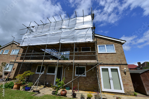 A Scaffold tower attached to a detached house in the UK photo