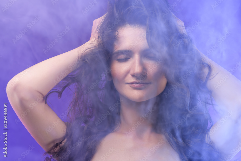 portrait of pretty naked girl with closed eyes in smoke on purple