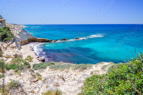 Fototapeta Naklejka Na Ścianę i Meble -  Beach, Greece - Kos Island, Kefalos: Picturesque deep blue Caribbean Bay with wild sea of ​​Greek Agais and steep sandstone cliffs, perfect for wind surfers with heavy waves