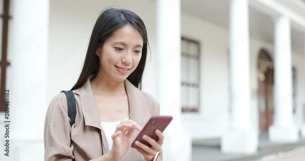 Woman sending text message on cellphone at outdoor Woman sending text message on cellphone at outdoor
