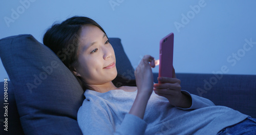 Woman use of mobile phone and lying down on sofa