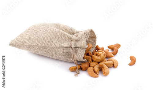 Cashew nuts in burlap sack isolated on white background