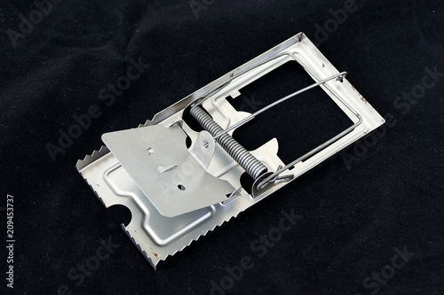 Photos metal mouse trap, standing on black ground,