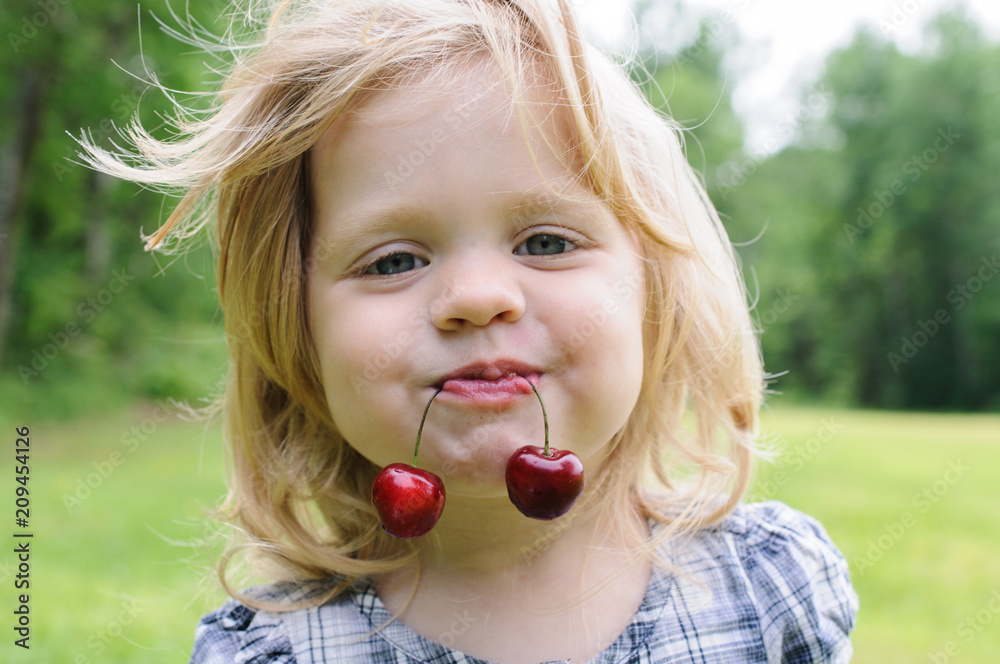 little girl with a sweet cherry in her mouth little girl with a sweet cherry in her mouth
