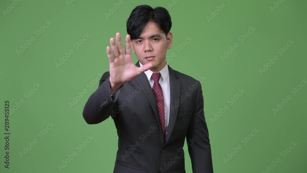 Young handsome Asian businessman gesturing to stop Young handsome Asian businessman gesturing to stop