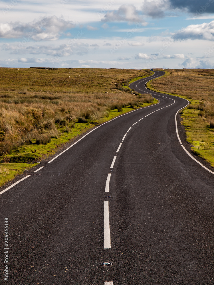 Fototapeta premium A windy road leading up hill in the Welsh Countyside of Brecon Beacons