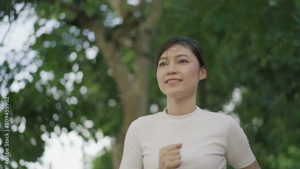 slow-motion of young woman running in park