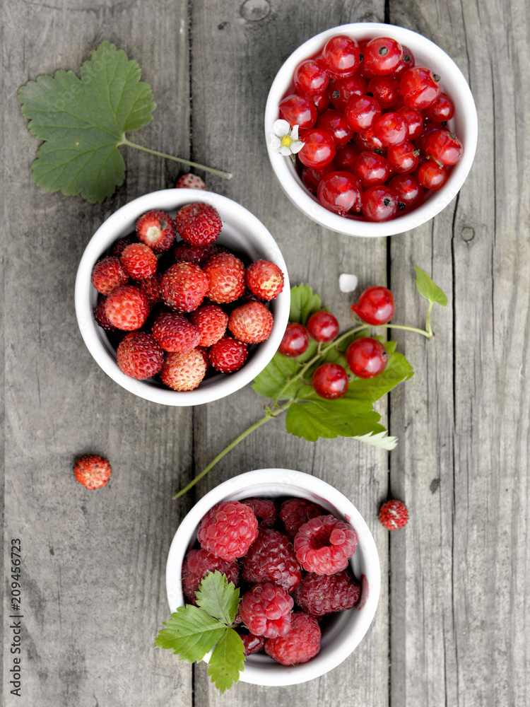 top view on red berries in little bowl on a wooden table top view on red berries in little bowl on a wooden table