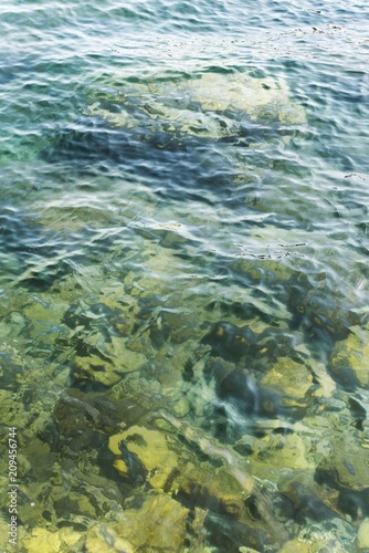 adriatic sea water waves with stones in shallow