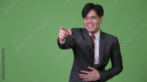 Young handsome Asian businessman laughing