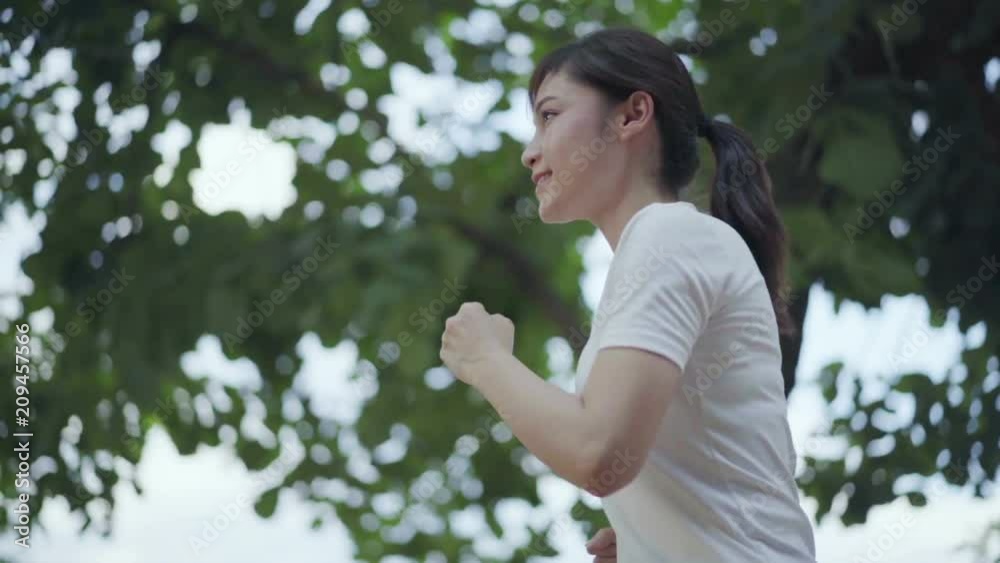 slow-motion of young woman running in park slow-motion of young woman running in park