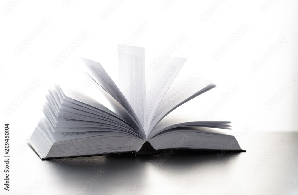 open book on a table on a light background of a brick wall open book on a table on a light background of a brick wall
