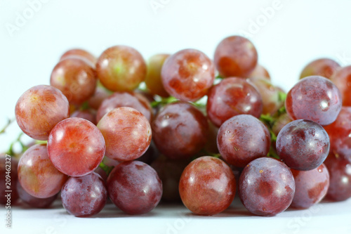 Red grapes on white background.