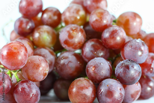 Red grapes on white background.