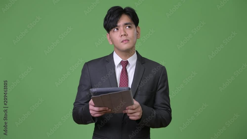 Young handsome Asian businessman using digital tablet Young handsome Asian businessman using digital tablet