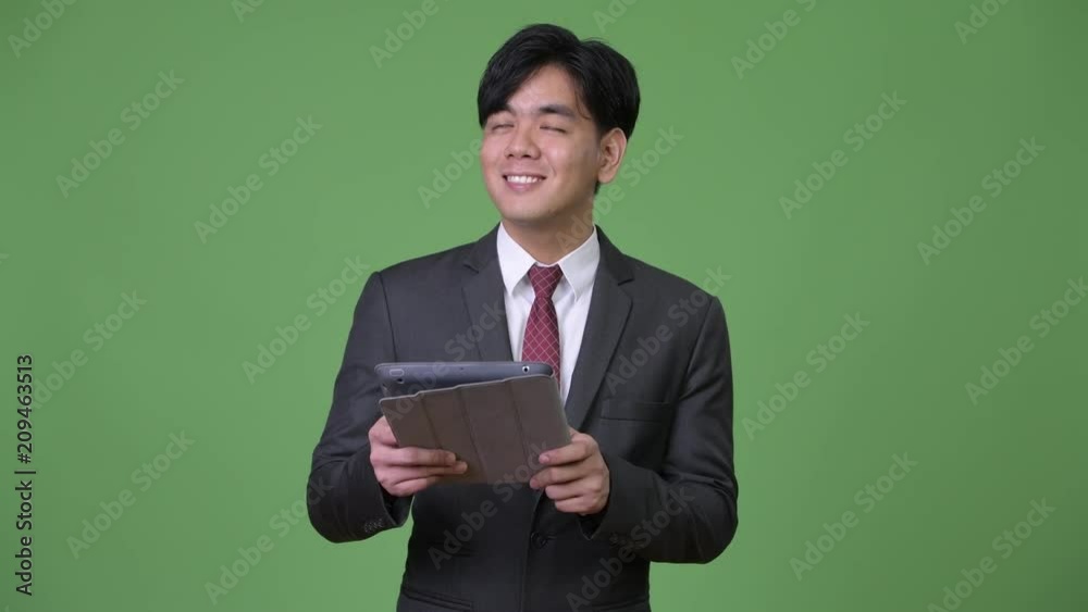 Young handsome Asian businessman using digital tablet Young handsome Asian businessman using digital tablet