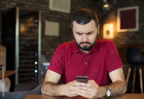 Stressed man using mobile phone
