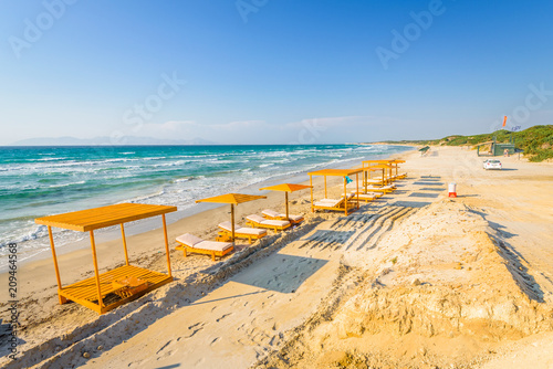 Beaches, Greece, Kos Island, Kochylari: beautiful holiday setting on a secluded beach with umbrellas on the Greek Aegean Sea with turquoise waters and a picturesque bay and islands in the background