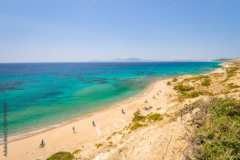 Beaches, Greece, Kos Island, Cap Helona: beautiful holiday setting on a secluded beach with umbrellas on the Greek Aegean Sea with turquoise waters and a picturesque bay and islands in the background