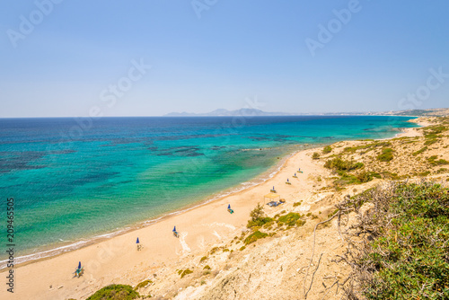Obraz na płótnie Beaches, Greece, Kos Island, Cap Helona: beautiful holiday setting on a secluded beach with umbrellas on the Greek Aegean Sea with turquoise waters and a picturesque bay and islands in the background w salonie