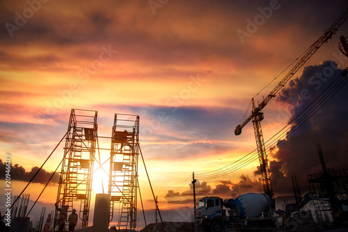 Construction site with crane and workers at sunset