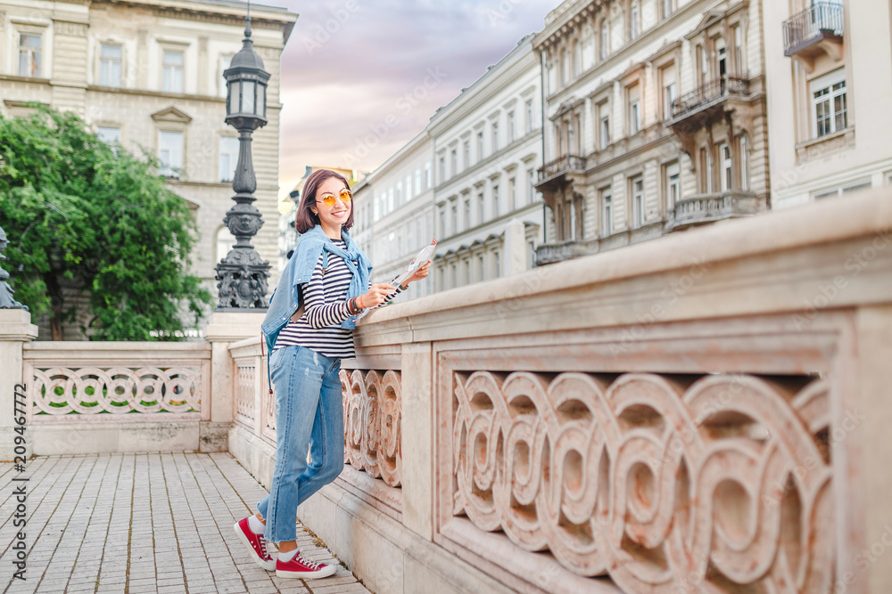 woman tourist looking at the map on the street of european city, travel to Europe concept