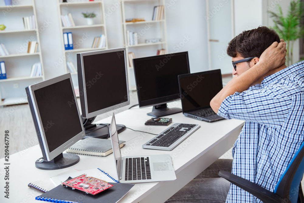 Businessman sitting in front of many screens Businessman sitting in front of many screens