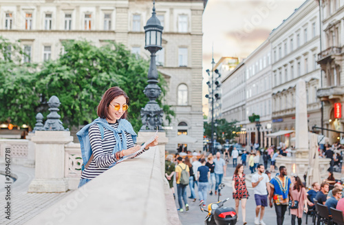 Photography woman tourist looking at the map on the street of european city, travel to Europ