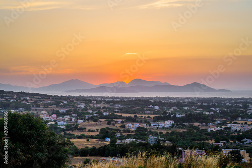 Kos Island, Town, Kalymnos, Greece - Warm sunset over the greek mediterranean sea near the turkish coast, viewed from the mountains of the island in a picturesque garden with many wildflowers