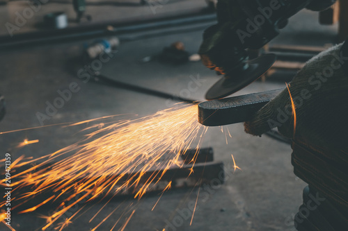 worker using  grinder steel in workshop and have  throwing sparks.