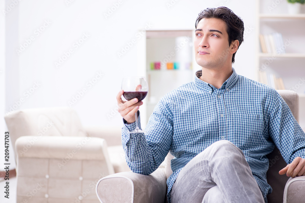 Young man drinking wine at home Young man drinking wine at home