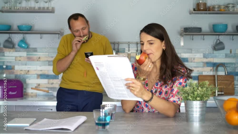 Young couple reading magazine by the table in home
Young couple reading magazine by the table in home