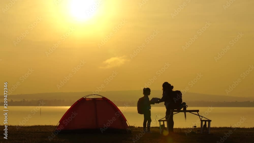 mother and daughter camping by the sea at sunset or sunrise mother and daughter camping by the sea at sunset or sunrise