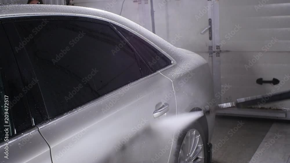 Man washing car under high pressure water Man washing car under high pressure water
