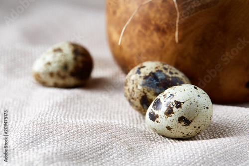 Bowl with eggs quail  eggs on a homespun napkin on wooden table  close-up  selective focus