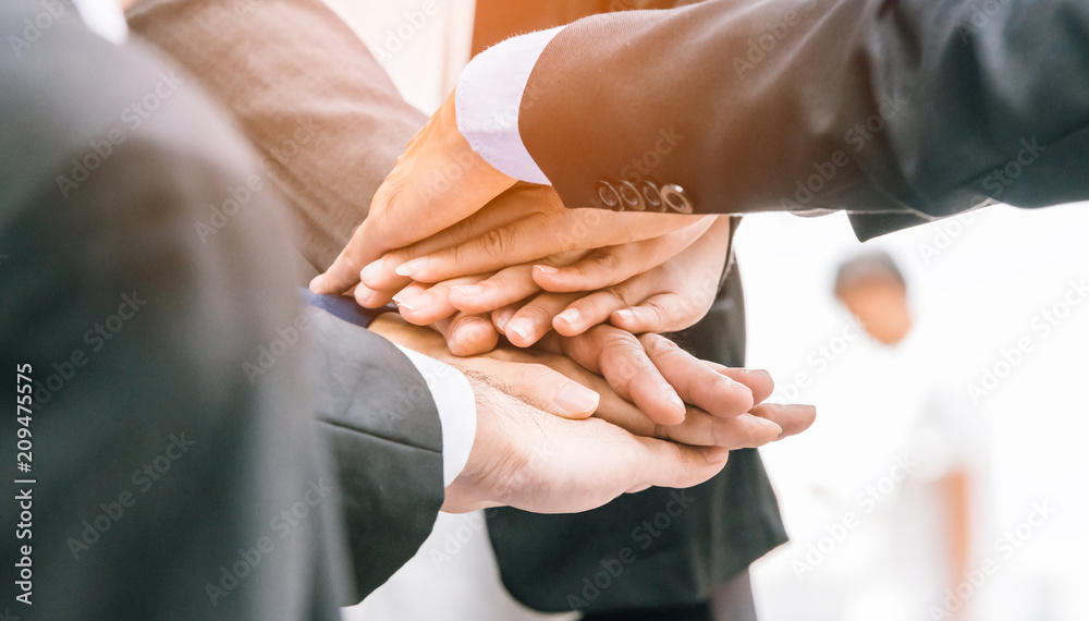  business people hands on top of each other Closeup of pile of hands of a team showing unity