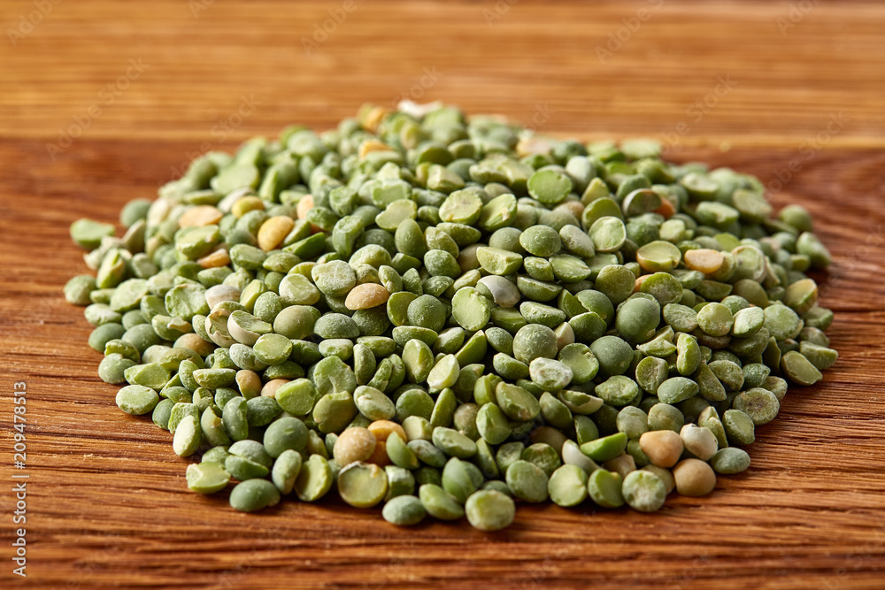 Pile of green peas on rustic wooden background, close-up, top view, selective focus. Pile of green peas on rustic wooden background, close-up, top view, selective focus.