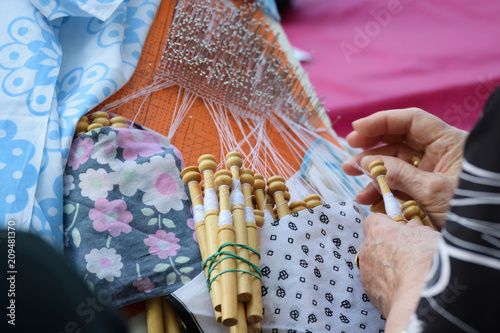 Active senior people workshop with traditional bobbin lace crochet. Hands detail and empty copy space for Editor's text.