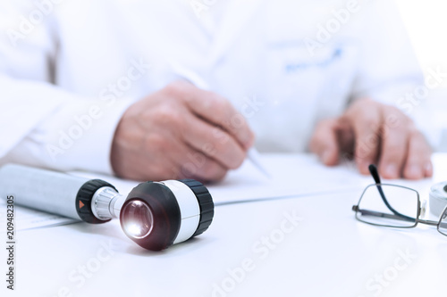 The doctor prescribers, amid Dermatoscope lying on the table