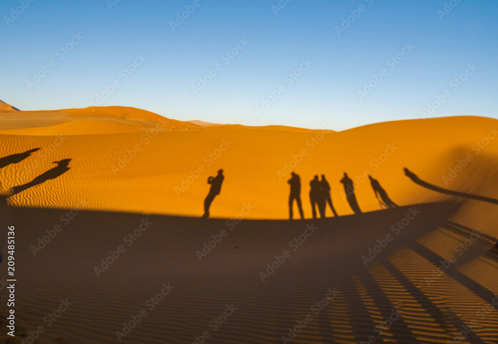 Shadows of group tourists in curve of dune of Hidden Vlei, Sossusvlie Namibia