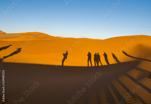 Shadows of group tourists in curve of dune of Hidden Vlei  Sossusvlie Namibia