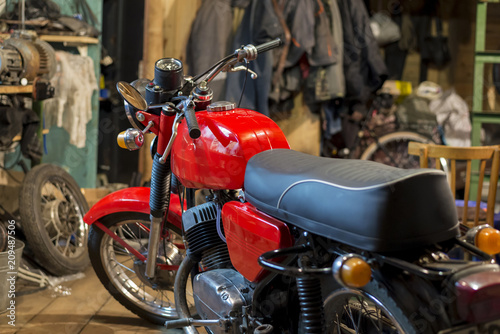 Red vintage motorcycle parked in the garage © Pavlo